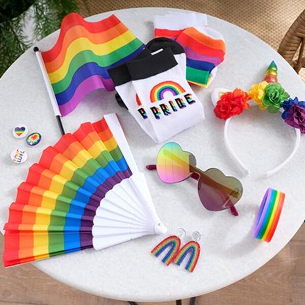 assorted pride apparel and rainbow décor on white table